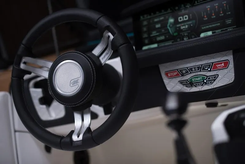 Slide: The Image of 2023 Nautique Ski boat steering wheel and dashboard controls. - 49