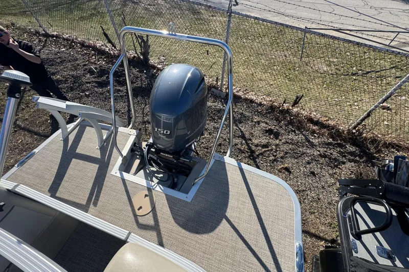 Slide: The Image of 2018 Bennington 22SSRX pontoon boat with Yamaha 150 outboard motor, parked near a fence. - 17
