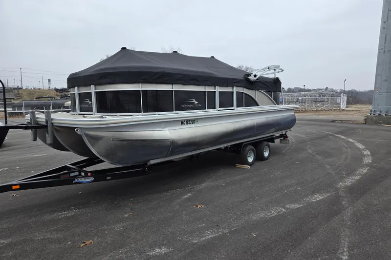 Slide: The Image of 2018 Bennington 22SSRX pontoon boat on trailer, covered and parked outdoors. - 22