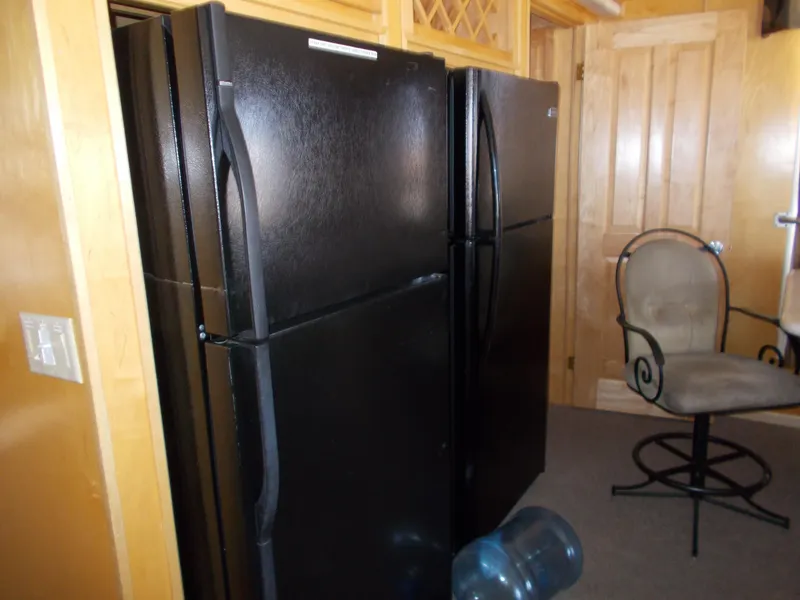 Slide: The Image of Two black refrigerators in a 2005 Stardust Cruisers Summer Obsession Trip 36 houseboat kitchen. - 16
