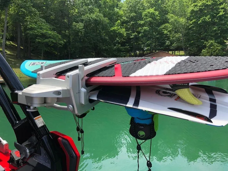 Slide: The Image of Wakeboards mounted on a Supra SE 450 boat, 2015 model, by a serene lake. - 13