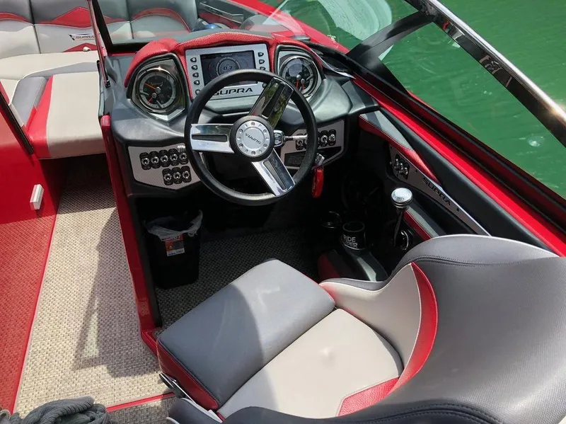 Slide: The Image of 2015 Supra SE 450 boat interior with red and gray seating, modern dashboard, and steering wheel. - 14