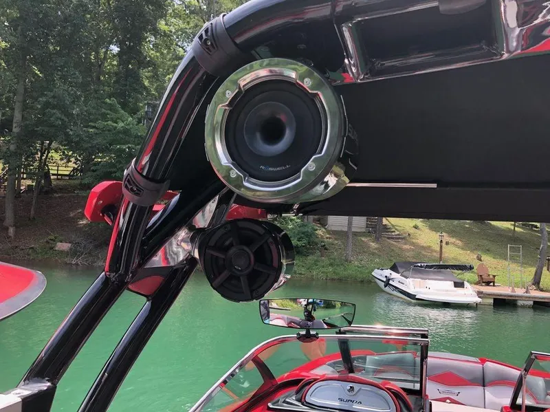 Slide: The Image of 2015 Supra SE 450 boat with speakers, docked on a serene lake. - 15