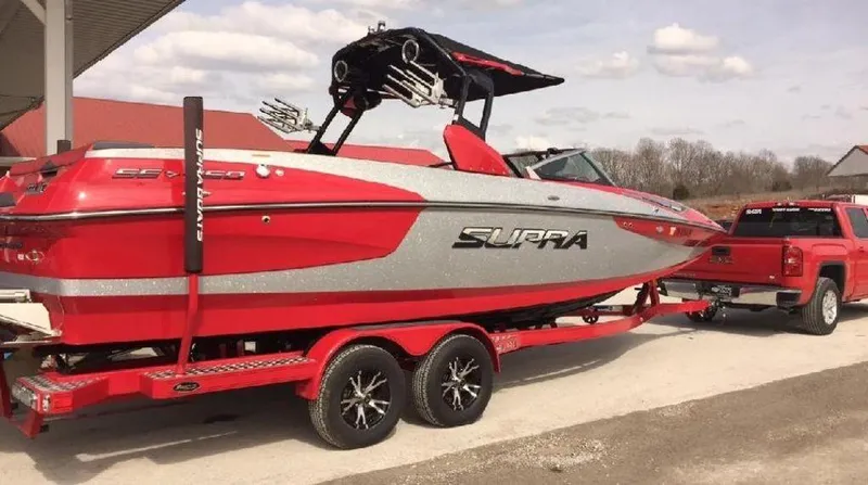 Slide: The Image of Red and silver 2015 Supra SE 450 boat on trailer, parked outdoors. - 2