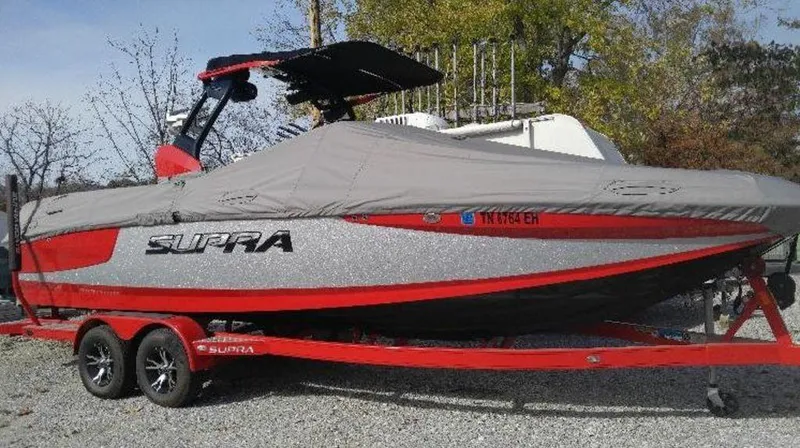 Slide: The Image of 2015 Supra SE 450 boat with cover on trailer, red and gray design. - 25