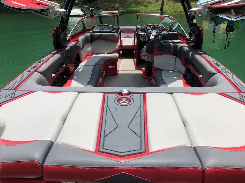 Slide: The Image of 2015 Supra SE 450 boat interior with red and gray seating, sleek design, and modern dashboard. - 28