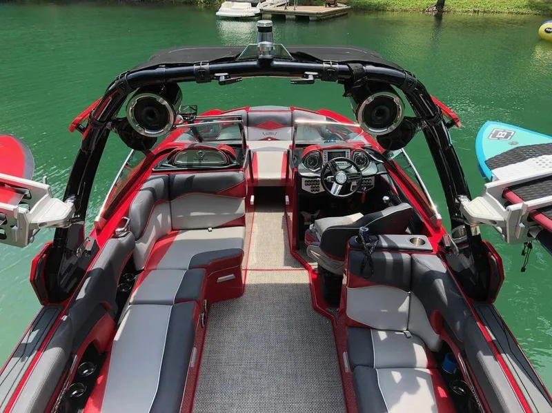 Slide: The Image of 2015 Supra SE 450 boat interior with red and gray seating, advanced dashboard, and lake backdrop. - 3
