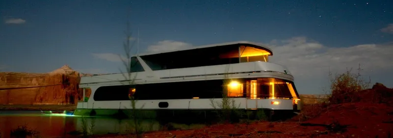 Slide: The Image of 2014 Bravada Infinity Trip #1 houseboat illuminated at night on a serene lake. - 1