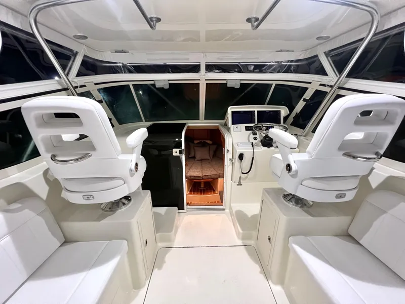 Slide: The Image of 2025 Henriques 30' Express boat interior with white seating and modern cockpit. - 14
