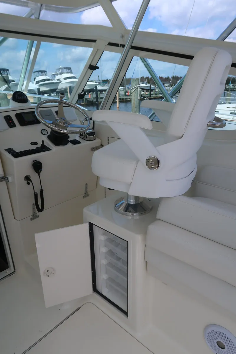 Slide: The Image of Helm station of 2025 Henriques 30' Express with captain's chair and open storage compartment. - 16