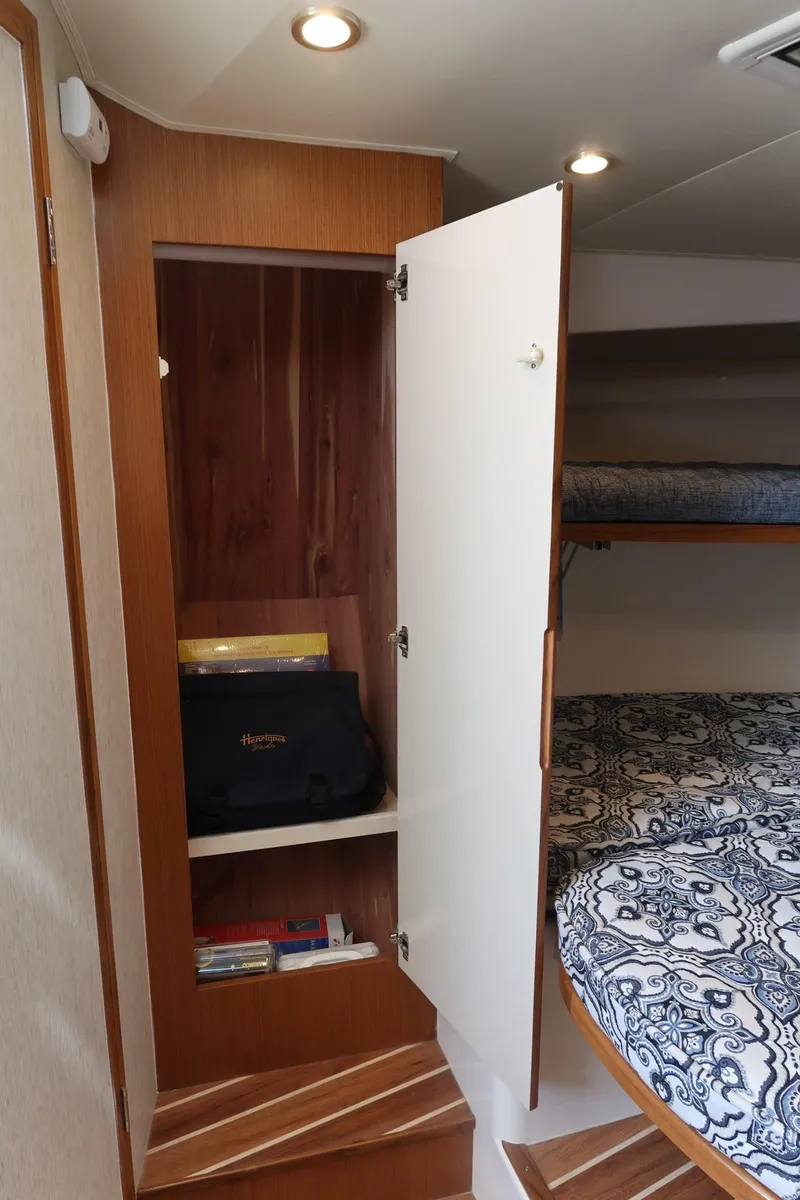 Slide: The Image of 2025 Henriques 30' Express cabin interior with open closet and bunk beds. - 24
