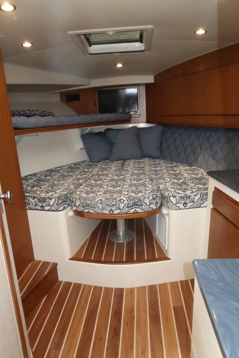 Slide: The Image of 2025 Henriques 30' Express cabin interior with bed, wood flooring, and overhead lighting. - 25