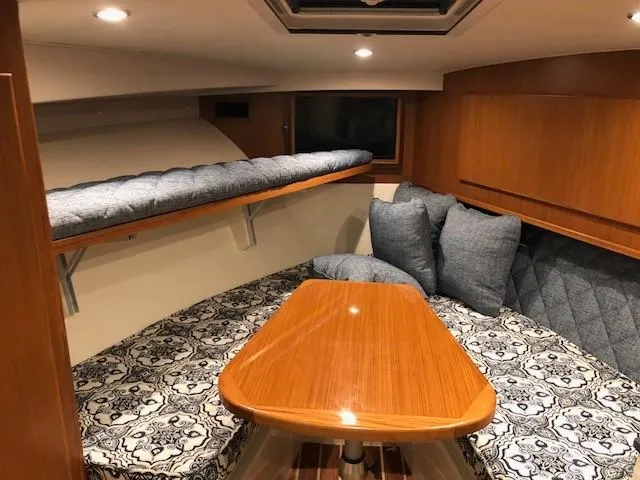 Slide: The Image of 2025 Henriques 30' Express cabin interior with wooden table and cushioned seating. - 26