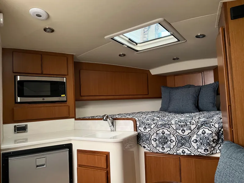 Slide: The Image of Interior cabin of 2025 Henriques 30' Express with bed, microwave, and skylight. - 31