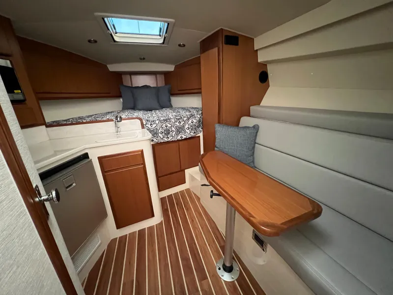 Slide: The Image of 2025 Henriques 30' Express cabin interior with bed, kitchenette, and seating area. - 32
