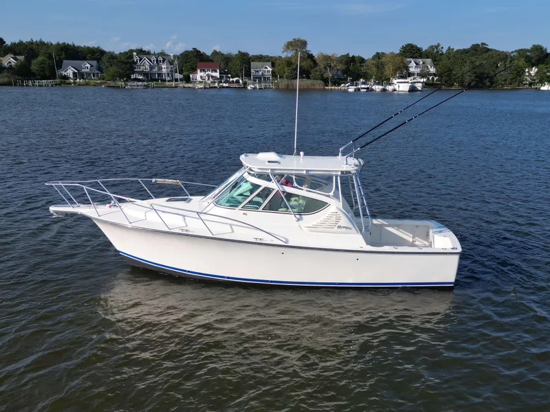 Slide: The Image of 2025 Henriques 30' Express boat on calm water near residential shoreline. - 4