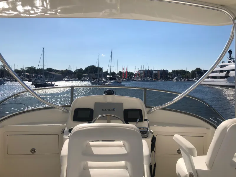 Slide: The Image of Helm of 2025 Henriques 42 Cruiser overlooking marina with boats. - 10