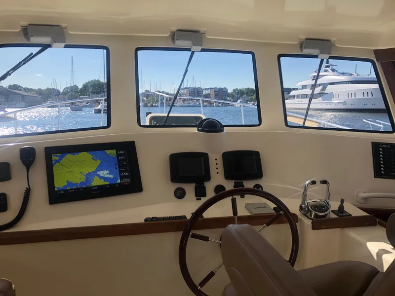 Slide: The Image of Henriques 42 Cruiser 2025 helm with navigation screens and marina view. - 15