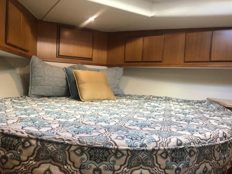 Slide: The Image of Cozy bedroom in 2025 Henriques 42 Cruiser with patterned bedding and wooden cabinets. - 16