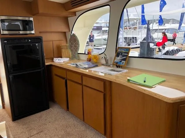 Slide: The Image of Interior of 2025 Henriques 42 Cruiser with kitchenette, microwave, and large windows. - 7