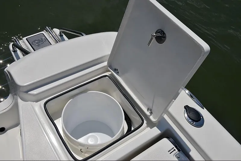 Slide: The Image of 2023 NauticStar 227 XTS boat with open storage compartment and bucket. - 13