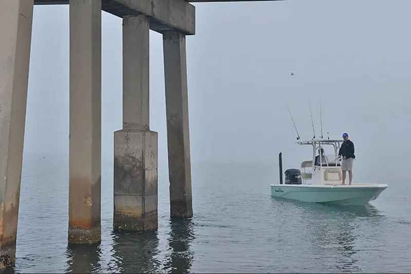 Slide: The Image of 2023 NauticStar 227 XTS boat near concrete pillars on a foggy day. - 20
