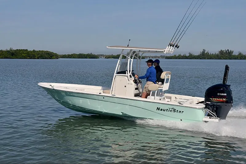 Slide: The Image of 2023 NauticStar 227 XTS boat cruising on a calm lake. - 3