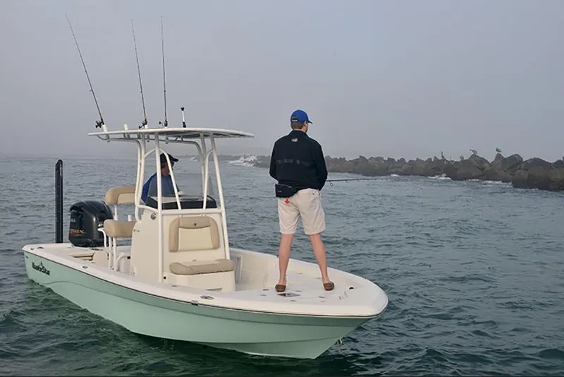 Slide: The Image of 2023 NauticStar 227 XTS boat with two people fishing in open water. - 5