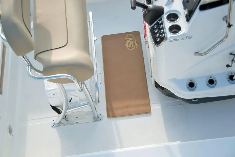 Slide: The Image of 2023 NauticStar 215 XTS boat interior with beige seating and console. - 16