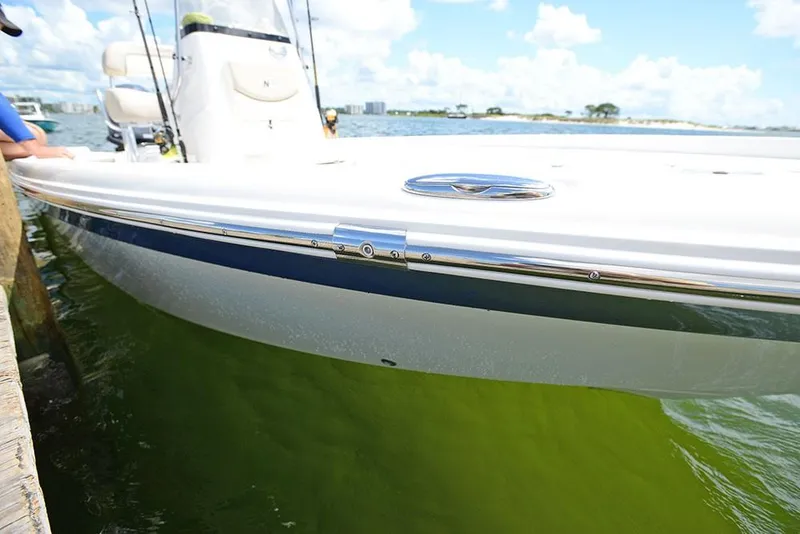 Slide: The Image of 2023 NauticStar 215 XTS boat docked in clear water on a sunny day. - 18