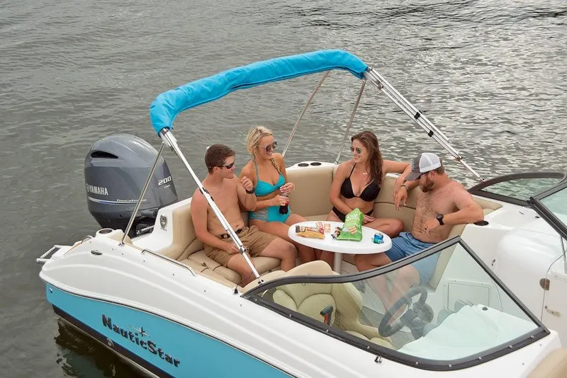 Slide: The Image of 2023 NauticStar 223DC Sport Deck boat with friends enjoying drinks on the water. - 5