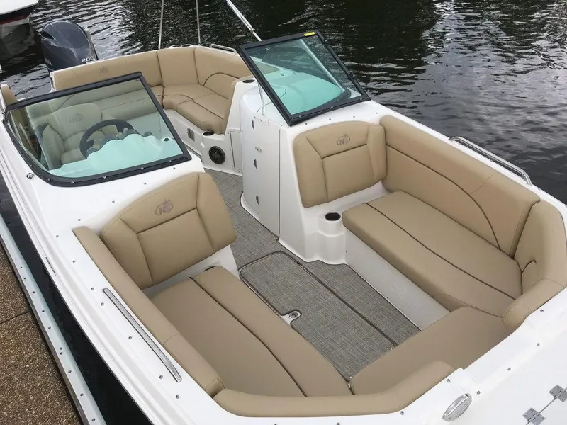 Slide: The Image of 2023 NauticStar 223DC Sport Deck boat with tan seating on the water. - 6