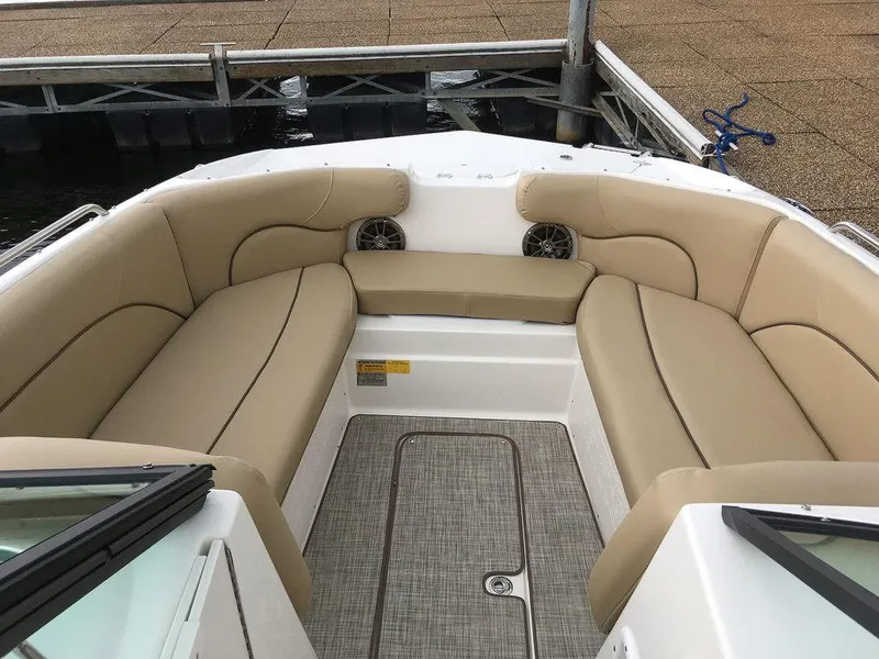 Slide: The Image of 2023 NauticStar 223DC Sport Deck boat with beige seating and spacious deck. - 8