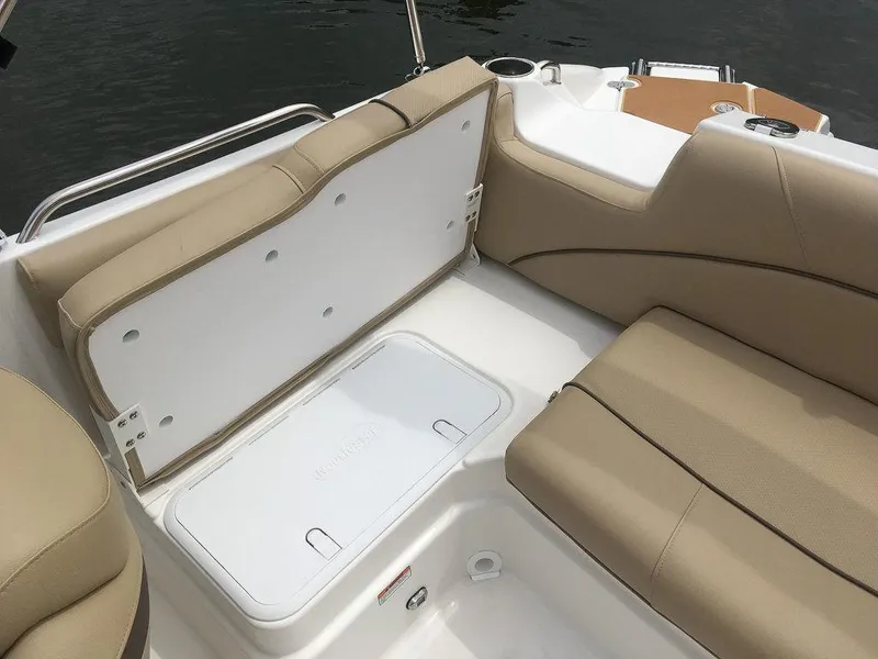 Slide: The Image of 2023 NauticStar 203DC Sport Deck boat interior with beige seating and storage compartments. - 19