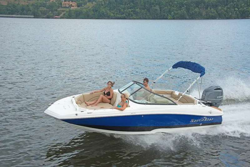 Slide: The Image of 2023 NauticStar 203DC Sport Deck boat cruising on a lake with passengers. - 3