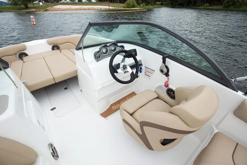 Slide: The Image of 2023 NauticStar 203DC Sport Deck boat interior with beige seating and steering console. - 6