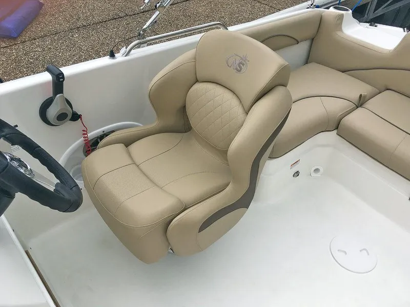 Slide: The Image of 2023 NauticStar 203SC Sport Deck boat with beige captain's chair and steering wheel. - 17
