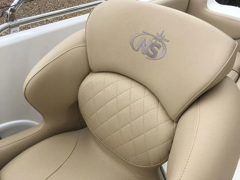 Slide: The Image of 2023 NauticStar 203SC Sport Deck beige cushioned seat with embroidered logo. - 18