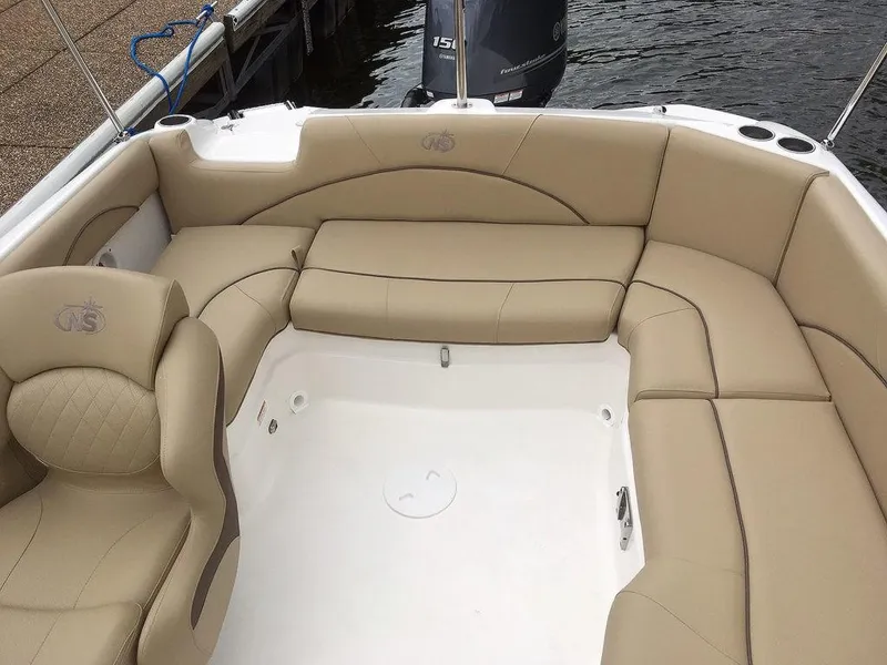 Slide: The Image of 2023 NauticStar 203SC Sport Deck boat with beige seating and spacious layout. - 23