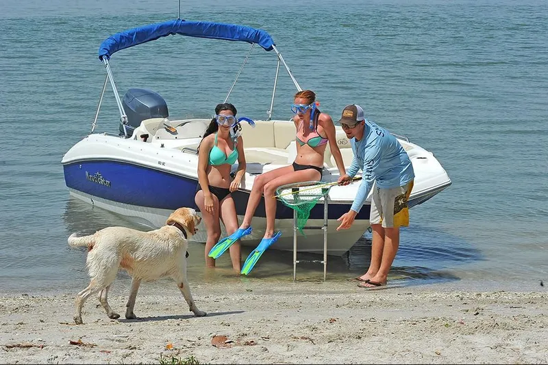 Slide: The Image of 2023 NauticStar 193 Side Console boat with people and dog on beach - 11