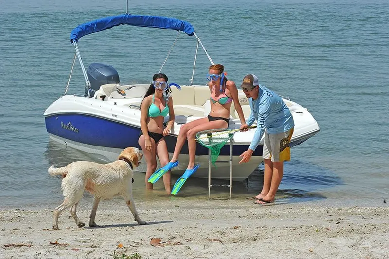 Slide: The Image of 2023 NauticStar 193 Side Console boat with people and dog on beach. - 12