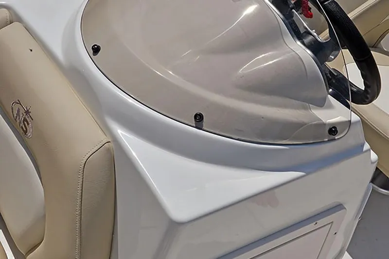 Slide: The Image of 2023 NauticStar 193 Side Console boat interior, featuring steering wheel and beige seating. - 25