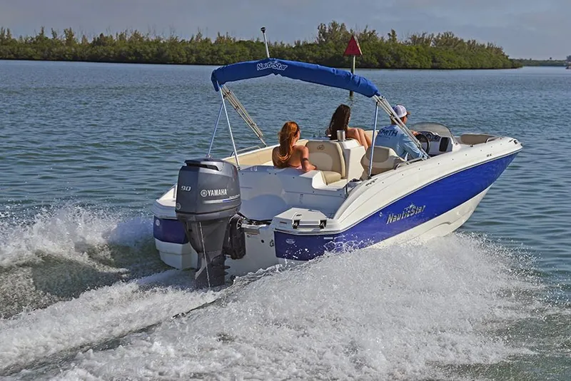 Slide: The Image of 2023 NauticStar 193 Side Console boat cruising on water with passengers. - 8