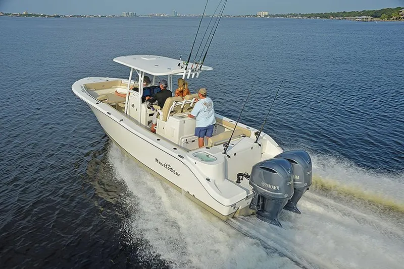 Slide: The Image of 2023 NauticStar 28 XS Offshore boat cruising on open water with passengers. - 10