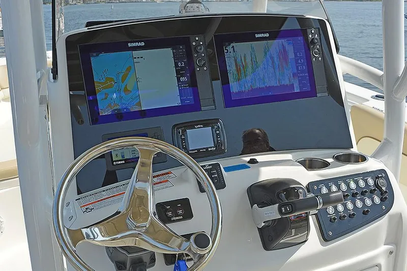 Slide: The Image of 2023 NauticStar 28 XS Offshore boat dashboard with Simrad displays and controls. - 14