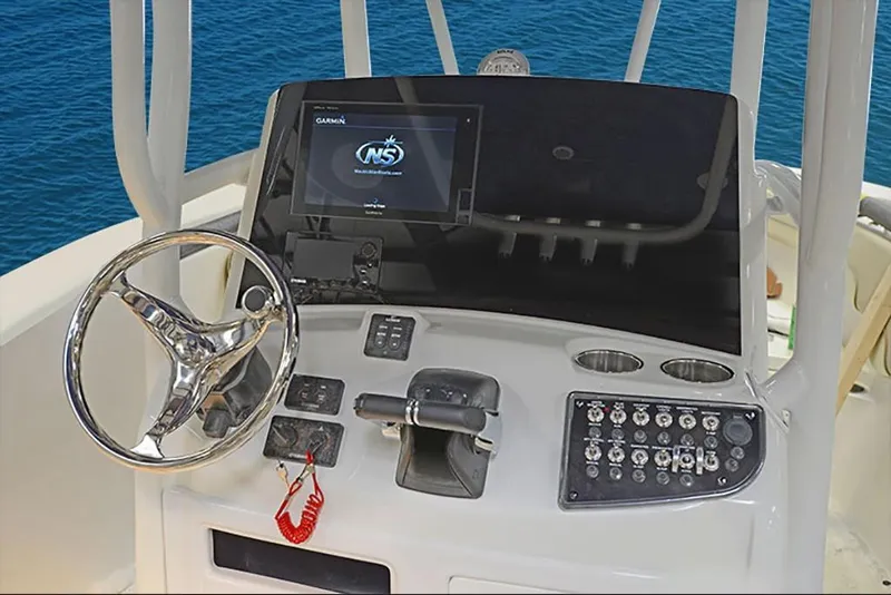 Slide: The Image of 2023 NauticStar 28 XS Offshore boat dashboard with steering wheel and control panel. - 15