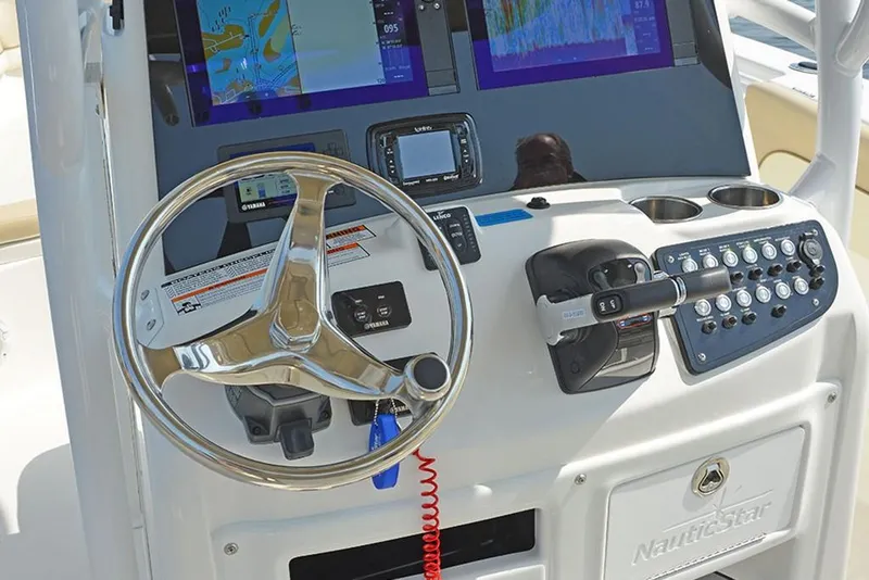 Slide: The Image of 2023 NauticStar 28 XS Offshore boat helm with steering wheel and navigation screens. - 19