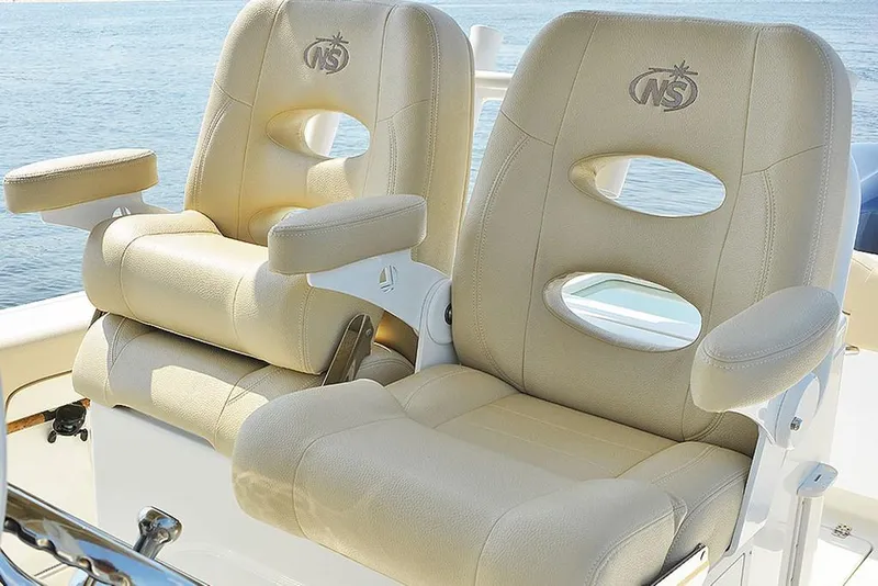 Slide: The Image of 2023 NauticStar 28 XS Offshore boat seats with armrests and logo. - 20