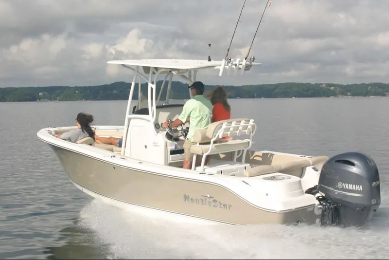 Slide: The Image of 2023 NauticStar 2302 Legacy boat cruising on a lake with passengers. - 15