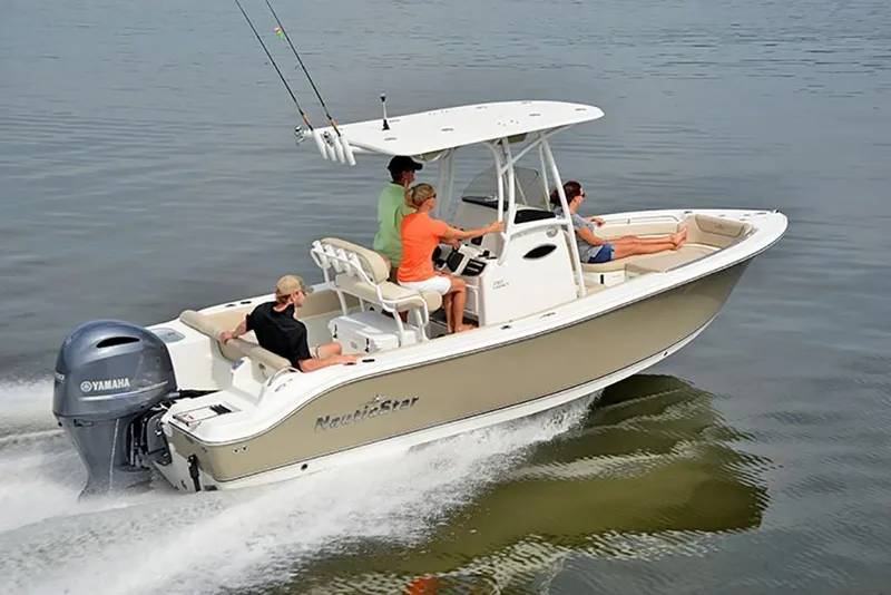 Slide: The Image of 2023 NauticStar 2302 Legacy boat cruising with passengers on calm water. - 2